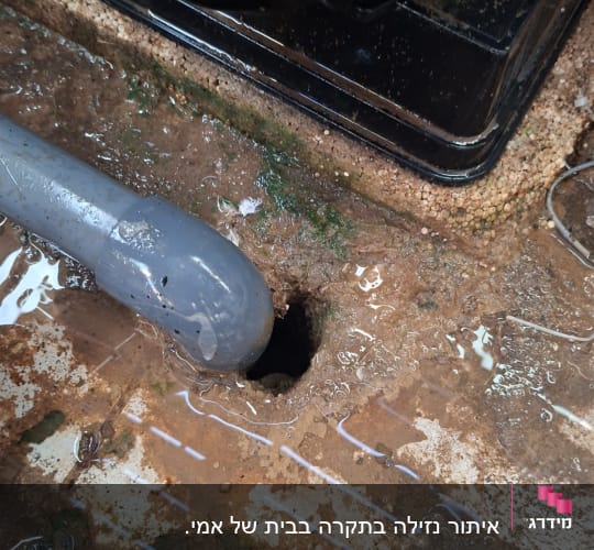 צינור ונזילה על רצפה רטובה עם חור